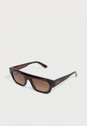 Gafas de sol rectangulares carey con lentes marrones degradados y el logotipo dorado "vogue" en las varillas y en la esquina de la lente.