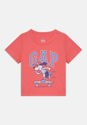 Koral lühike varrukas T-särk, mis on valmistatud puuvillast, millel on graafika koerast rulluiskudel koos sinise ja valge "GAP" tekstiga.