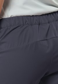 Navy Hose mit elastischem Bund aus einem glatten, leichten Stoff, der an der Taille dezent gerafft ist und ein minimalistisches Design aufweist.