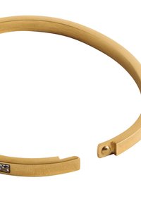 Złota bransoletka w formie bangla o gładkim, matowym wykończeniu, z prostokątnym akcentem z przezroczystego kamienia z jednej strony oraz otwartą konstrukcją.