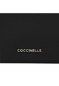 Portafoglio in pelle nera texturizzata con logo "Coccinelle" in tonalità oro, caratterizzato da cuciture accurate e un design minimalista.