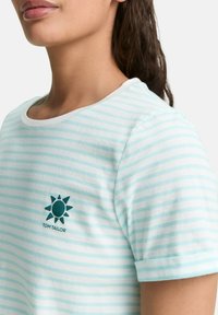 T-shirt rayé bleu clair avec des manches courtes, col rond, et un graphique de soleil avec le texte "TOM TAILOR" sur le devant. Tissu en coton doux.