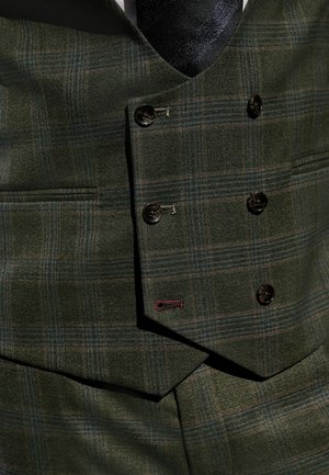 Grüner karierter Weste aus strukturiertem Stoff mit einem doppelt geknöpften Design, das dunkle Knöpfe und ein kontrastierendes rotes Steppdetail aufweist.