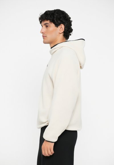 Kapuzensweatshirt aus cremefarbenem Stoff mit entspannter Passform, featuring schwarze Akzente am Ausschnitt und an den Bündchen, einfaches Design ohne Muster.