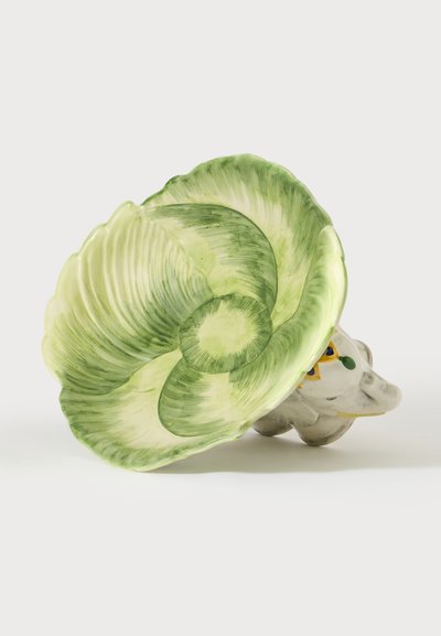 Bol en céramique vert et crème en forme de feuille de chou avec une base figurine d'éléphant blanc et jaune sur fond blanc.