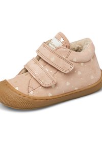 Scarpa in velcro di morbido camoscio rosa chiaro con motivi a forma di cuore beige, suola in gomma, punta arrotondata e una presa testurizzata sul fondo.