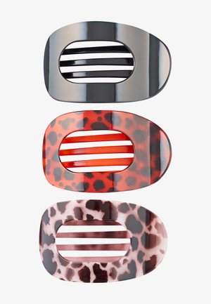 Drie ovaalvormige haarclips met horizontale staven; één zwart, één rood met zwarte vlekken, één roze met donkerbruine vlekken.