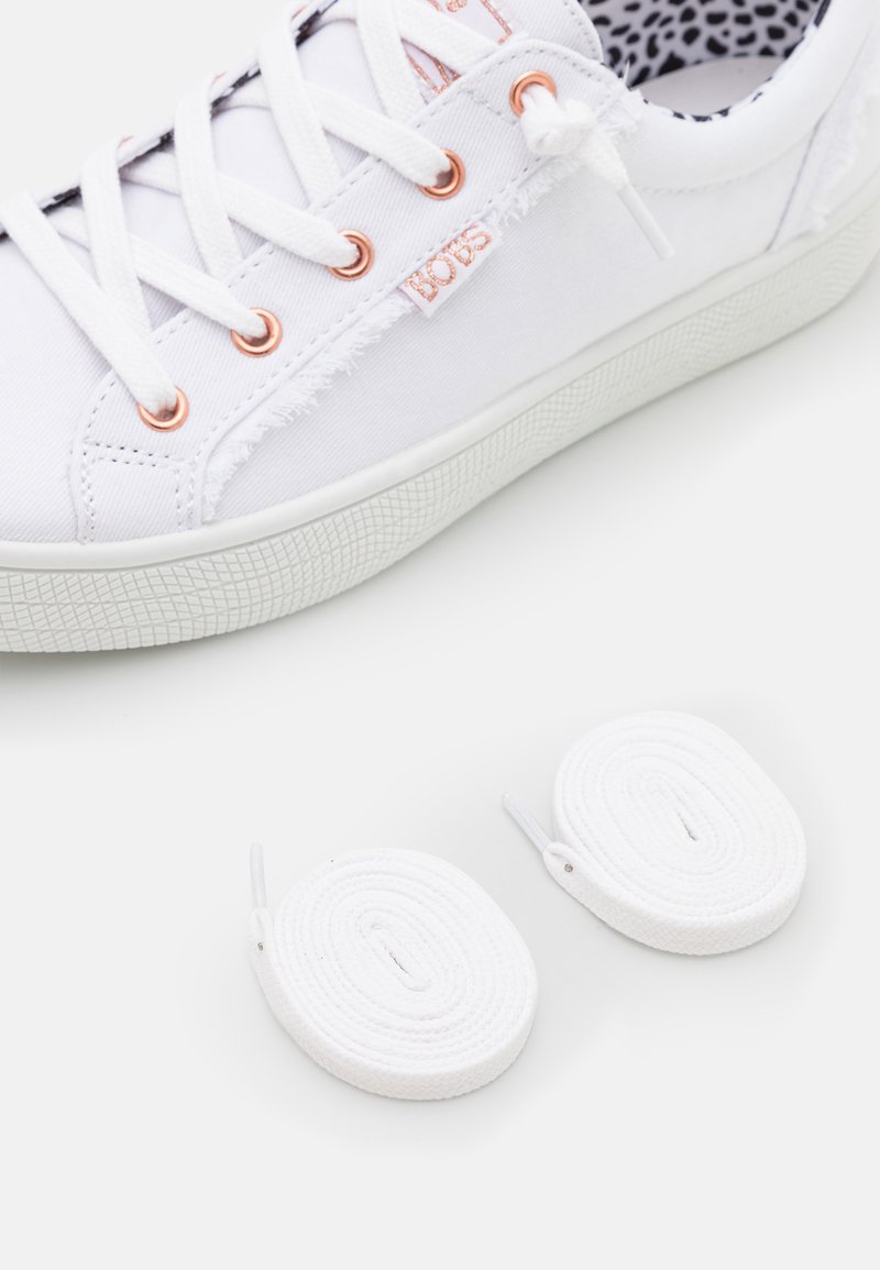Sneaker bianca in tela con occhielli in rame e bordi sfrangiati. Include due paia di lacci bianchi. Suola in gomma testurizzata.