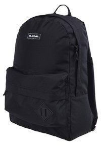 Zaino in tessuto nero di forma rettangolare, con tasca frontale con zip, toppa con logo e un accento a forma di diamante nella parte inferiore. Texture liscia.