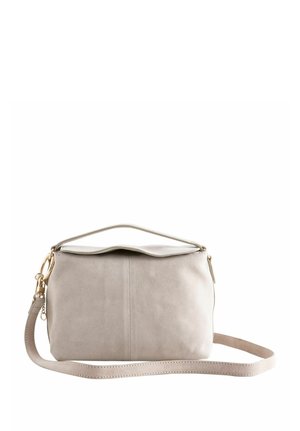 Light beige rectangular handbag with a top handle and detachable long strap, soft material, and gold-toned hardware on a white background.