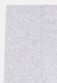 Light gray leggings featuring a soft, textured fabric with a subtle pattern. Visible stitching runs down the front and back.
