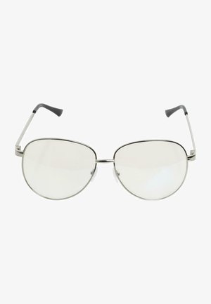 Svetle růžová baseballová bunda se stříbrnými patentkami a bílým žebrovaným límcem. Dlouhé rovné vlasy a velké kulaté brýle s modrým nádechem.