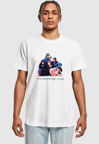 Hvit bomull t-skjorte med grafisk trykk av seks karakterer og teksten "THE BREAKFAST CLUB" under, rund hals, korte ermer.
