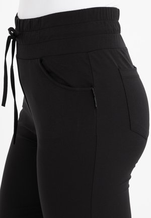 Zwarte joggingsbroeken met een elastische tailleband met trekkoord, zijzakken en een gladde, elastische stof, ontworpen voor comfort en pasvorm.