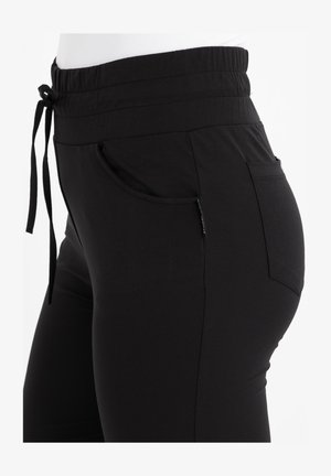Zwarte joggingsbroeken met een elastische tailleband met trekkoord, zijzakken en een gladde, elastische stof, ontworpen voor comfort en pasvorm.