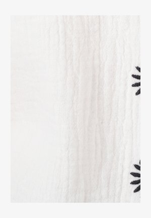 Witte stof met een gestructureerde weving en zwarte bloemachtige borduursels. Het ontwerp heeft een zachte, geweven uitstraling.