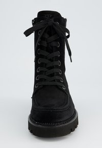 Bottines en suede noir à lacets avec un bout arrondi, semelle en caoutchouc épaisse et œillets métalliques. Comprend une fermeture éclair sur le côté et des accents texturés.