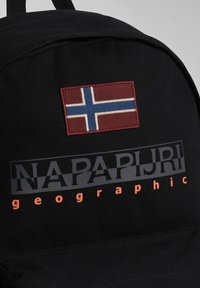 Čierny batoh s látkovou nášivkou s norskou vlajkou. Logo "NAPAPIJRI" v sivej farbe a "geographic" v oranžovej, výrazný dizajn.