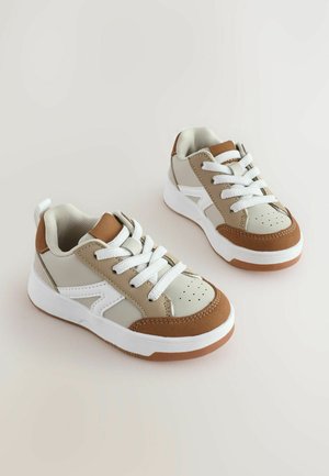 Sneakers med en beige, brun och vit färgsättning. Syntetiskt ovandel med mesh-textur, perforerad tå och vita snören. Gummisula.
