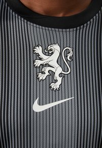 Gray and black striped athletic shirt with a lion logo and white Nike swoosh; made from lightweight, textured material.