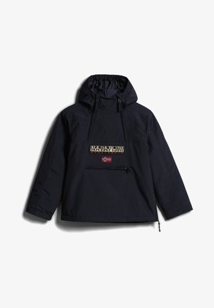 Osoba ubrana w czarną kurtkę Napapijri i pasujące spodnie z niebieskim logo, trzymająca niebieską dzianinową czapkę i czarne trampki na białym tle.