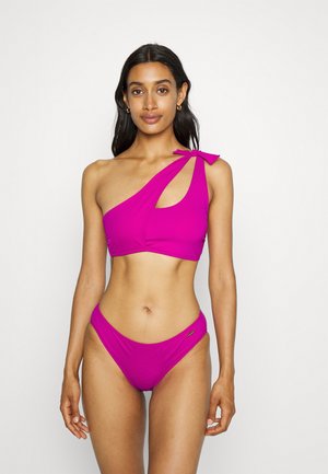 Ensemble de bikini rose à une épaule avec un détail en nœud sur l'épaule, texture lisse et design à découpe sur le haut.