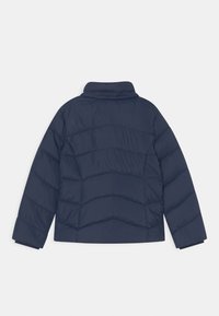 Mörkblå vadderad jacka med hög krage, horisontell sömnad och elastiska ärmslut. Tillverkad av lätt, slät material.