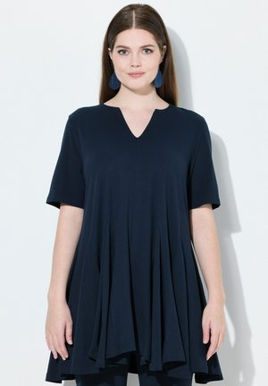 Tunic blu navy con maniche corte, scollo a V e dettagli plissettati per una vestibilità rilassata, realizzata in un tessuto morbido e fluido.