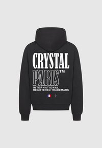 Felpa nera con tasca a marsupio, caratterizzata da grande testo bianco: "CRYSTAL PARIS™," "MARCHIO COMMERCIALE INTERNAZIONALE REGISTRATO," e un dettaglio della bandiera francese.