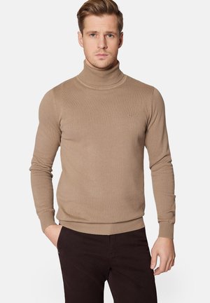 Beżowy sweter z golfem wykonany z prążkowanego materiału, z długimi rękawami i dopasowanym krojem. Mały detal z logo w okolicy klatki piersiowej.