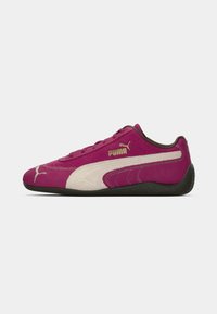 Sněrovací obuv Puma s fuchsiovým semišem a krémovými akcenty, texturovaným bočním panelem a černou gumovou podrážkou. Přítomný zlatý detail loga.