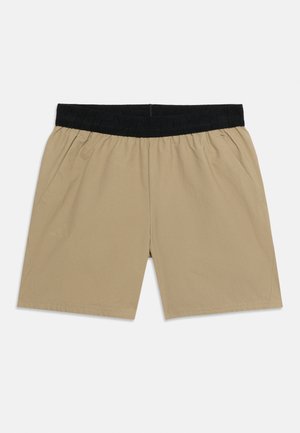 Shorts décontractés beige avec une large ceinture élastique noire et des poches latérales, posés à plat sur un fond clair.