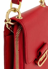 Czerwona syntetyczna torebka z fakturowaną powierzchnią, złotymi akcentami, zapięciem na zamek i klapką z metalowym detalem. Gruba łańcuchowa rączka.