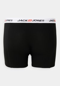 Schwarze Boxershorts mit einem weißen Bund, der das "JACK & JONES"-Logo in Schwarz und Rot zeigt. Glatte Textur mit einem enganliegenden Design.