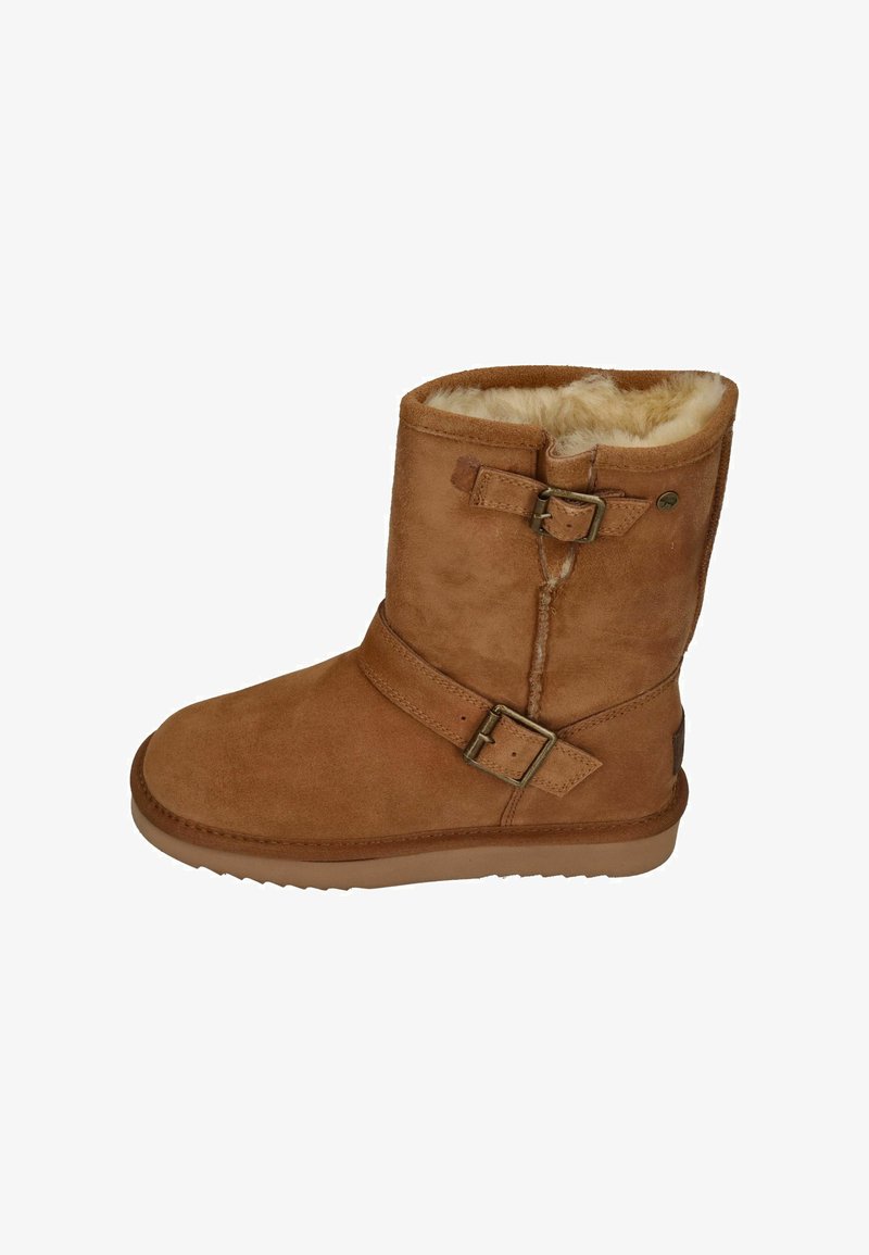 Tan suède laars met een faux fur voering, voorzien van twee decoratieve gespen en een platte rubberen zool. Ronde neus en hoogte tot de midden van de kuit.