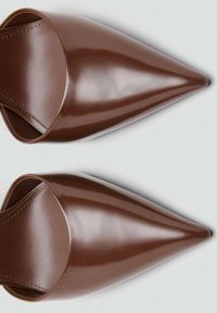 Scarpe slip-on marroni, a punta, con una superficie liscia e lucida e cuciture visibili lungo i bordi. Design elegante e minimalista.