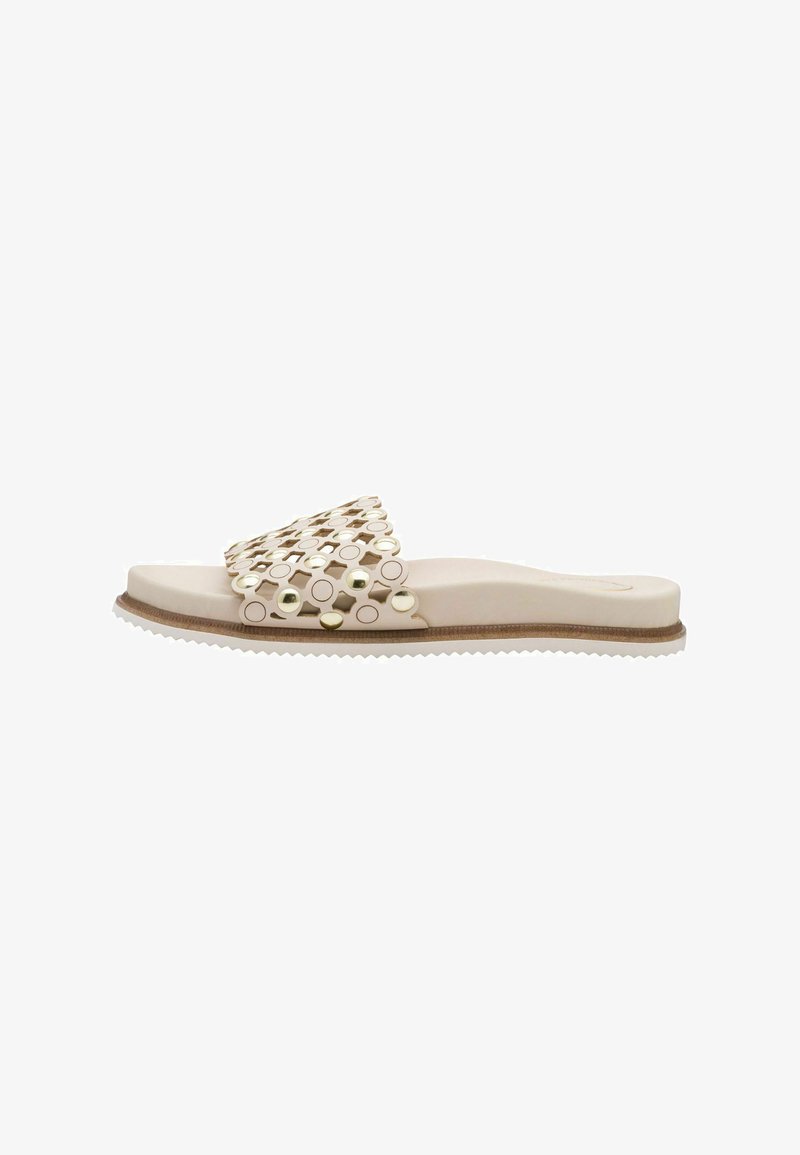 Sandale à glissière avec une base beige et un design circulaire découpé avec des accents métalliques. Semelle texturée avec une légère élévation.