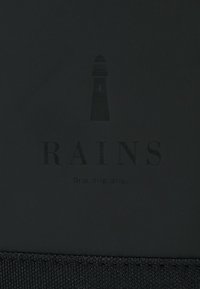 Surface noire avec un graphique de phare au-dessus du mot "RAINS" et la phrase "Drip, drip, drip." en texte plus petit en dessous.
