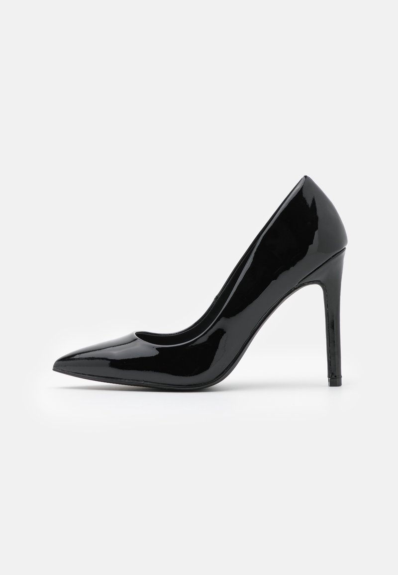 Chaussure à talon haut en cuir verni noir, à bout pointu et talon aiguille, vue de profil sur fond blanc.