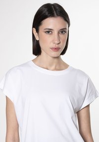 T-shirt bianco a maniche corte con scollatura rotonda, realizzato in tessuto morbido, caratterizzato da una vestibilità comoda e una texture liscia.
