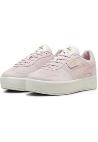 Puma sneakers in lichtroze suède met een witte rubberen platformzool, met een gladde bovenkant, rond vetersysteem en gouden merkuitsparingen.