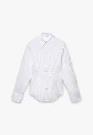 Chemise blanche à manches longues en tissu lisse, dotée d'un col classique, de boutons sur le devant et de détails froncés sur les côtés.