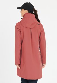 Vandtæt, lang pink jakke med hætte, der har et bagpleat. Stoffet er glat med en let glans; inkluderer et logo på skulderen.
