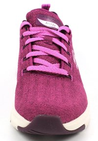 Zapatilla deportiva morada con una parte superior de tela texturizada, cordones rosas y una suela blanca y morada. Presenta una etiqueta "ArchFit" en la lengüeta.