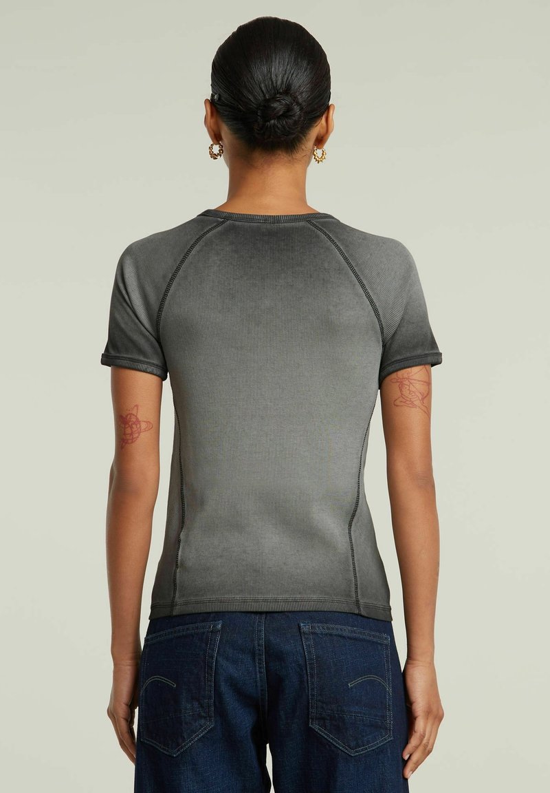 Maglietta grigia a maniche corte con righe, collo rotondo e maniche raglan, con cuciture a contrasto e una silhouette aderente.