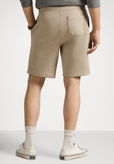 Beige shorts i bomullsblandning med en figursydd design, en enda bakficka och en slät textur, som slutar strax ovanför knäet.