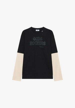 Maglia nera a maniche lunghe con maniche beige a strati, collo rotondo e scritta "GCDS Rockers" sul petto in stampa scura.