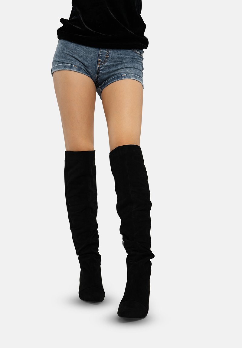 Zwarte suède laarzen over de knie met een aansluitend ontwerp en een ronde neus. Textuurstof met geplooide details aan de bovenkant.