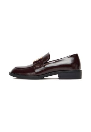 Burgundowe skórzane loafersy o eleganckim designie, z dekoracyjnym paskiem i przeszyciami. Podeszwa jest czarna i lekko teksturowana dla lepszej przyczepności.