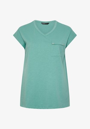 Muntgroene blouse met korte mouwen, V-hals en een klepzak op de borst die is gesloten met twee zilveren knopen.